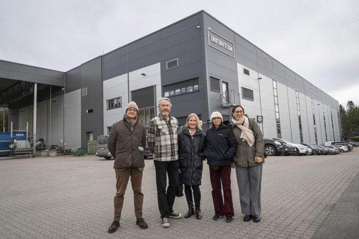 Fem mennesker står foran Infinitums anlegg på Heia